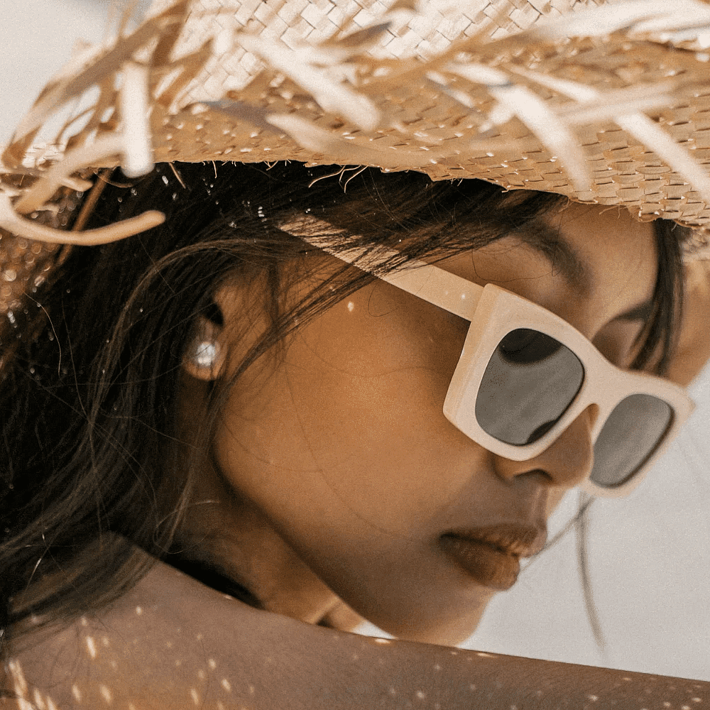 Woman in a straw hat and sunglasses enjoying the sunny weather.